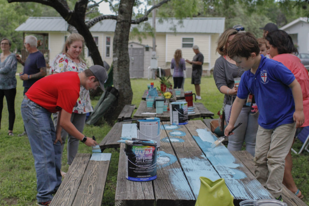 Concan community members painting our first turquoise table
